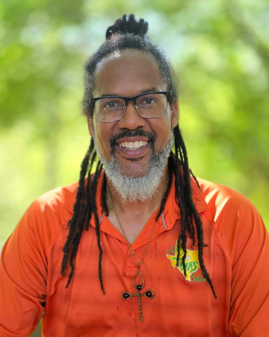Chef Tony Ingram smiling in an orange Tony's Tejas Salsa shirt
